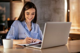 Foto: lächelnde Frau mit Laptop
