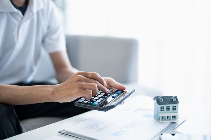 Foto: Mann tippt auf Taschenrechner