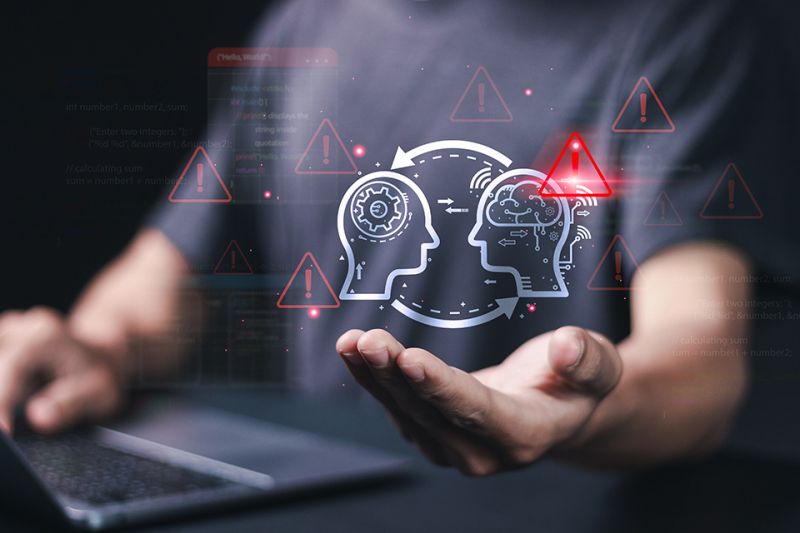 Foto: Abstrakte Köpfe mit Warndreiecken über Hand von einer Person